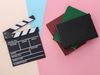 For a quiz about books/film adaptations. Clapper board and books or scripts. cinema, movies, motion pictures, clapboard, hollywood
