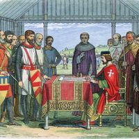 Illustration of King John seated at a table signing the Magna Carta. Other men stand watching. 