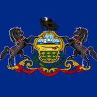 In 1907 the Pennsylvania state flag was approved. It uses the state coat of arms designed in 1777 to replace the coat of arms of William Penn, the former proprietor of the colony. The field is of national blue, which poses a problem of visibility for the black horses standing on gold scrollwork on either side of the shield. The motto “Virtue, Liberty, and Independence” runs beneath them on a banner. Like many other state flags, Pennsylvania's is bordered with a knotted yellow fringe.