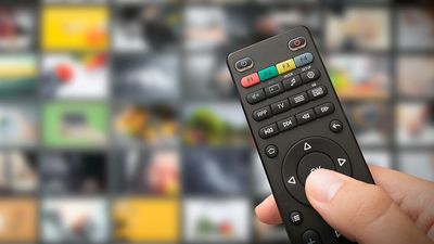 Hand on TV remote. Television remote. Binge watching. Streaming TV shows. Television apps and programs