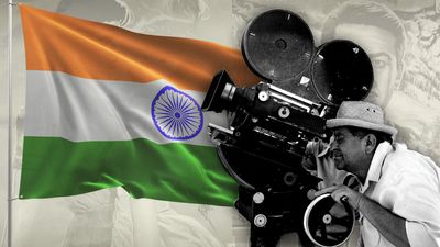 A photo montage of a colorful Indian flag waving on a white paper background, and a black & white photo of two Indian filmmakers peering through a large film movie camera.   