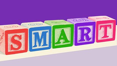 Wooden toy blocks spell the word "SMART."