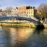Halfpenny bridge spans the River Liffey in Dublin, Ireland. The city takes its name from the Liffey's dark waters, called dubh linn (black pool) in Irish.